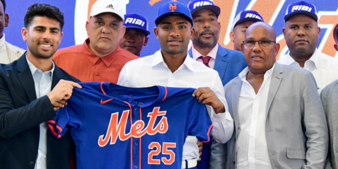 Elian Peña exhibe la camiseta de los Mets, minutos después de estampar su firma de 5 millones. Figuran el padre del novato, así como sus entrenadores Javier Rodríguez y Carlos Hernandez