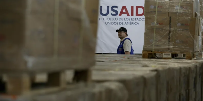 Un hombre pasa junto a cajas de ayuda humanitaria de USAID en un depósito del Puente Internacional Tienditas, en las afueras de Cúcuta, Colombia, el 21 de febrero de 2019, en la frontera con Venezuela.